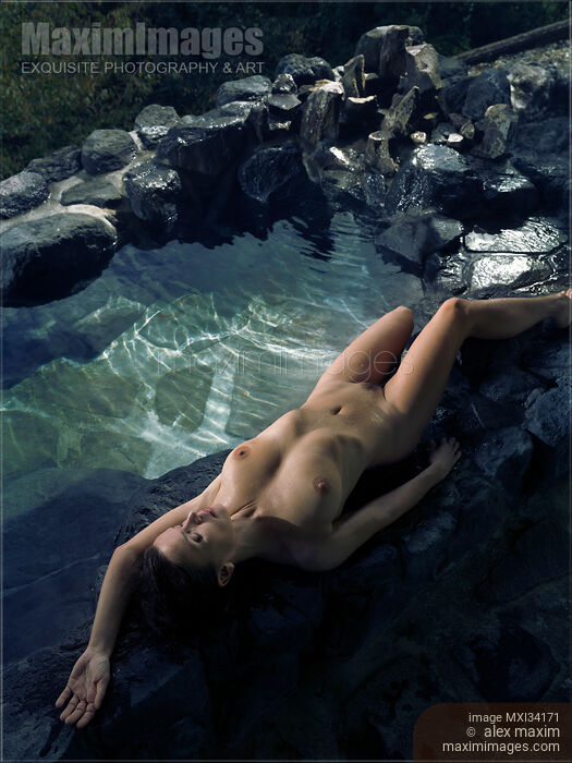 Beautiful nude woman with wet naked body lying on rocks of Japanese Onsen hot spring bath Stock Image MXI34171 © Alex Maxim / MaximImages