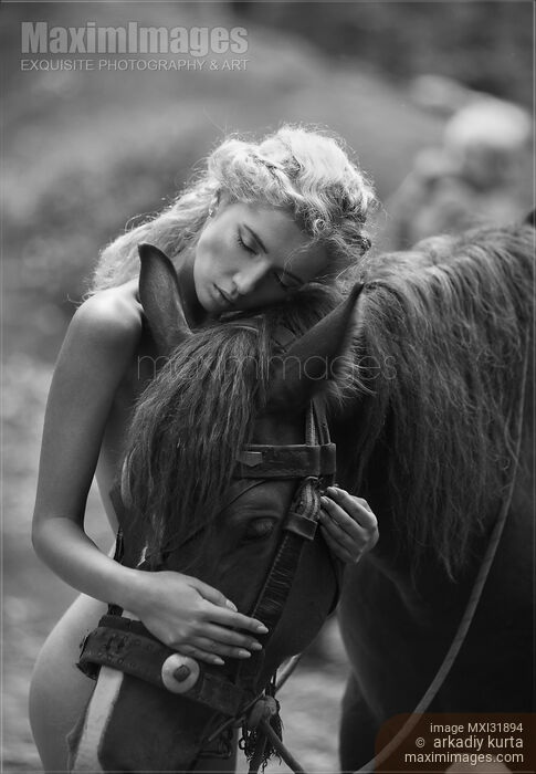 Fine art black and white photograph of a naked woman hugging a horse in the forest Stock Image MXI31894 © Arkadiy Kurta / MaximImages